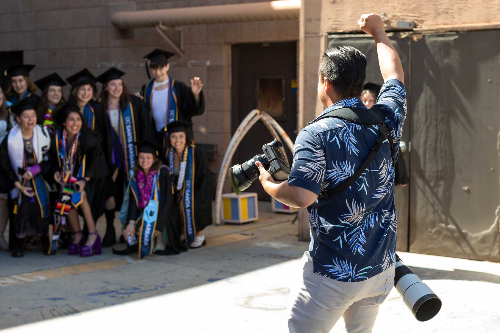 Photographer calling for attention from the grads for a photo shoot